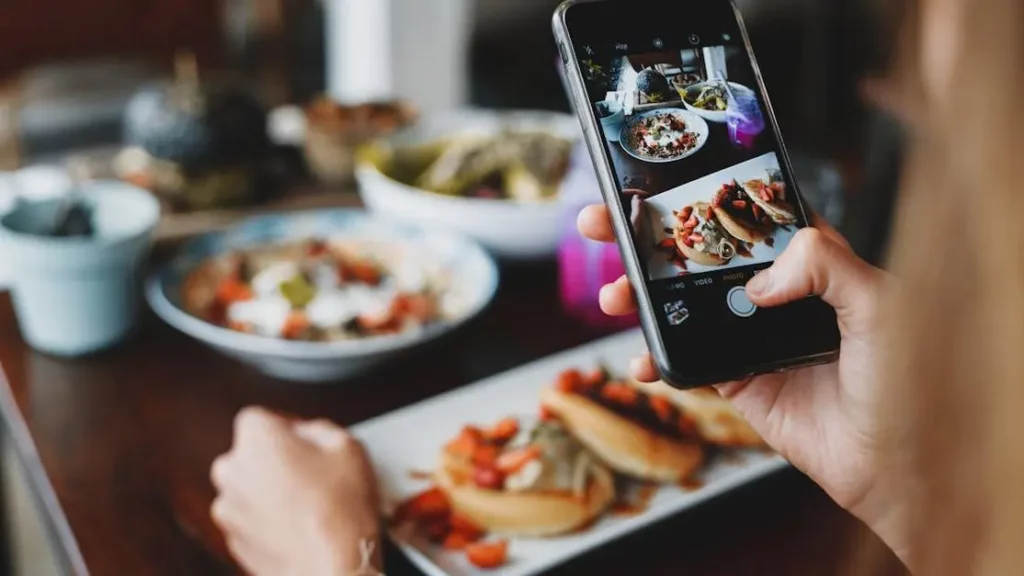 Mobile Charging Kiosks In Restaurants with customer photographing food in cafe