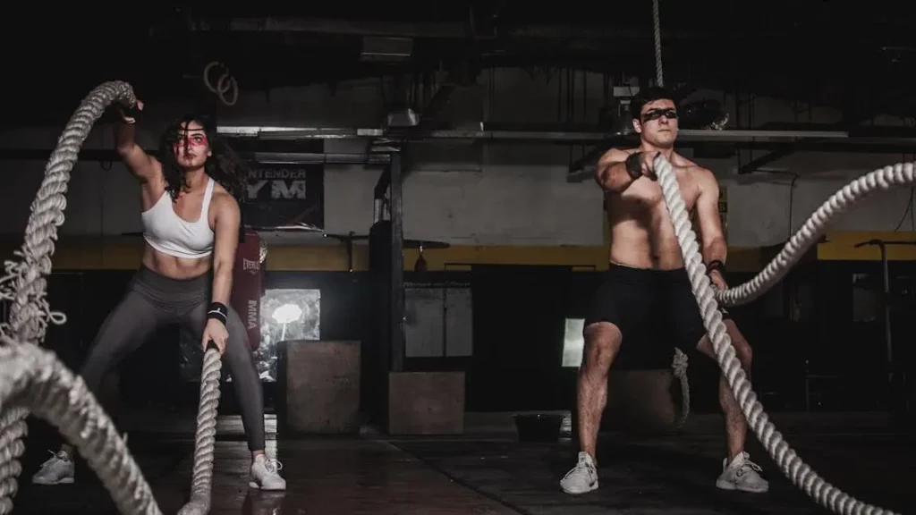 Gym members with battle ropes embrace mobile charging solutions.