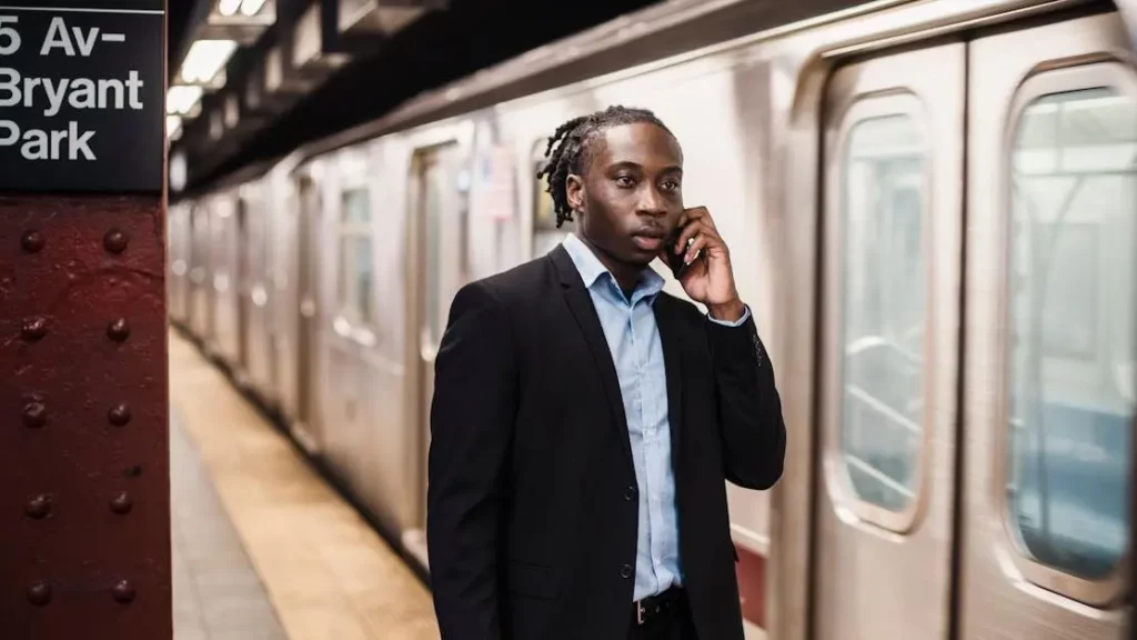 African American man in suit using phone near underground train station, Renting Phone Charging Stations article cover