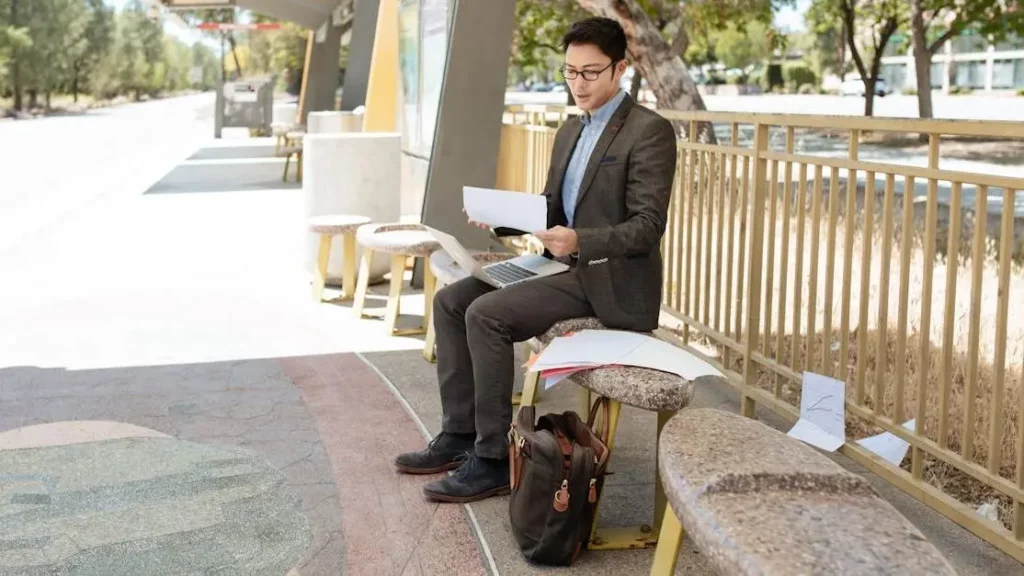 Businessman using phone at phone charging station.