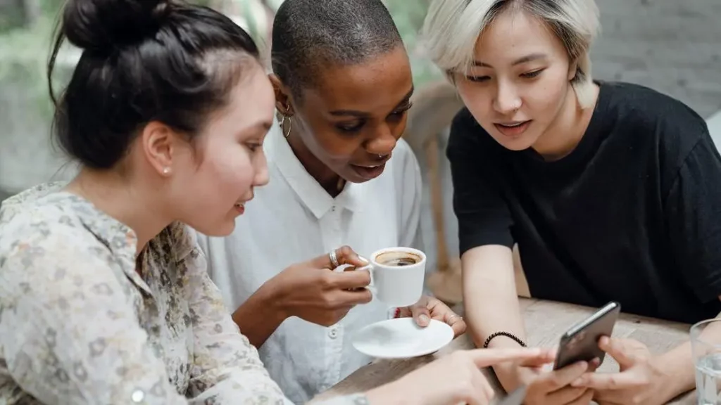 Friends use phone charging kiosks in cafe to improve customer experience.