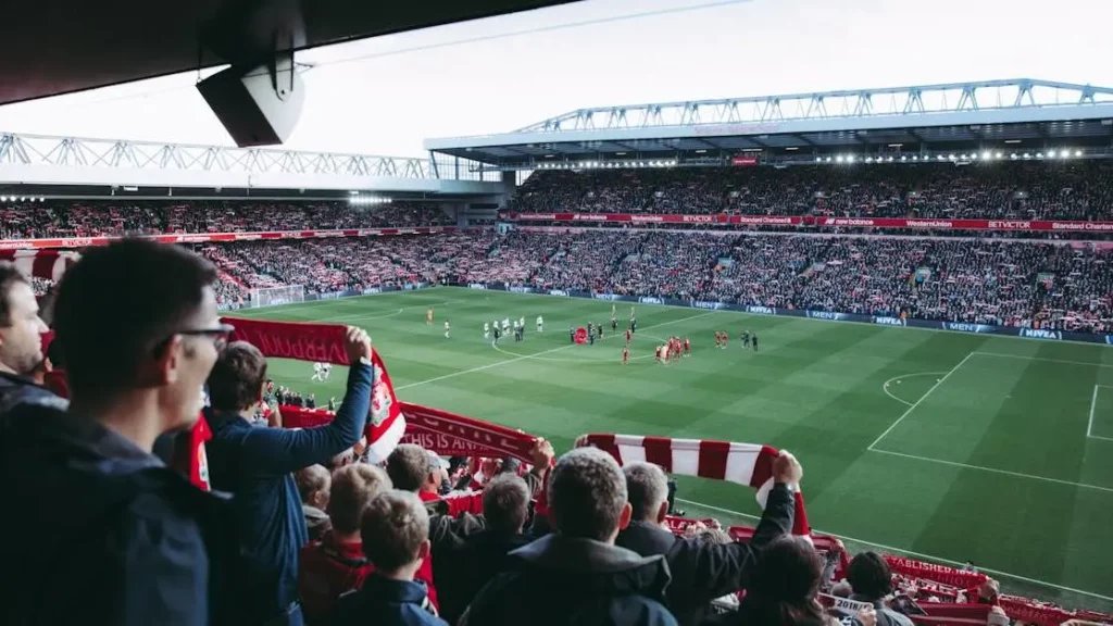 Fans cheer in a vibrant football stadium highlighting Mobile Phone Charging Stations For Stadiums.