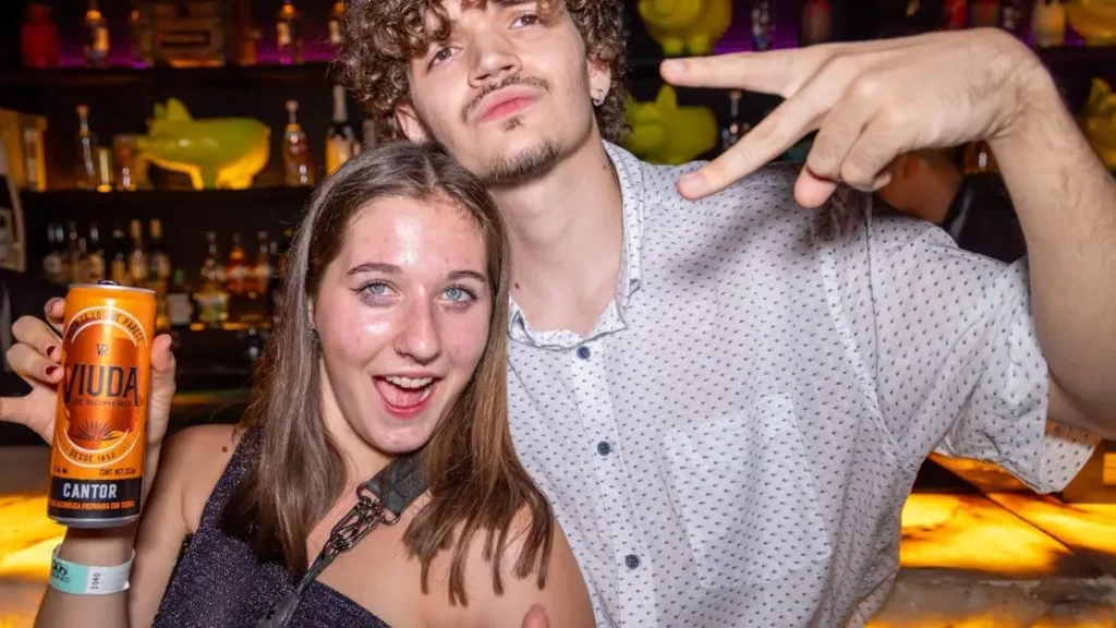 Young adults using Mobile Charging Kiosks in Bars, enjoying a vibrant night out.