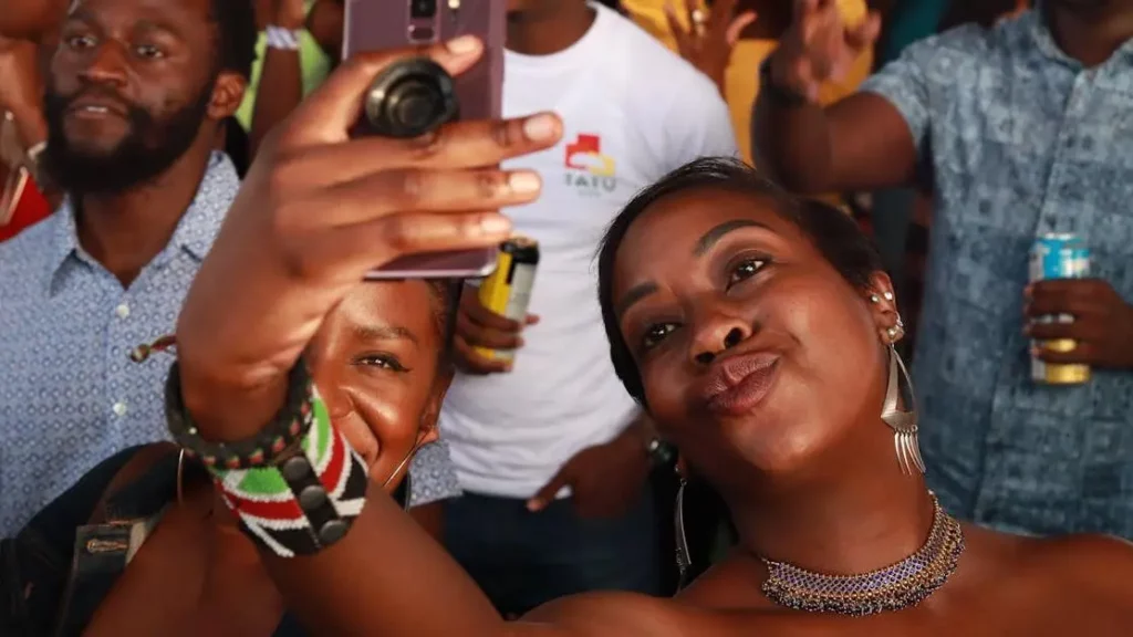 Joyful attendees taking a selfie at an event; renting charging stations boosts event attendance.