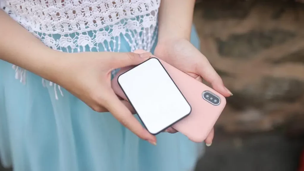 Woman holding smartphone and power bank, highlighting why portable charging kiosks are the future of customer convenience.