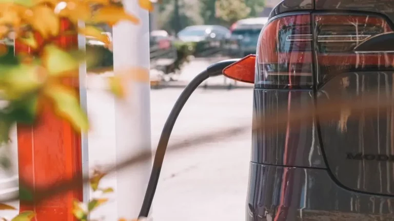 Electric car charging at a station, highlighting "5 Features to Look for in a Phone Charging Rental Station".