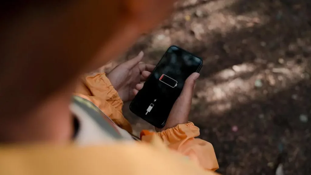 Teen with low battery smartphone outdoors highlights "Dead Phone Batteries Impact Customer Dwell Time".