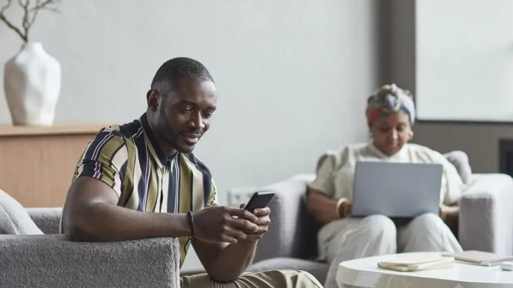 Colleagues utilizing charging options in a modern hotel lobby work setting.