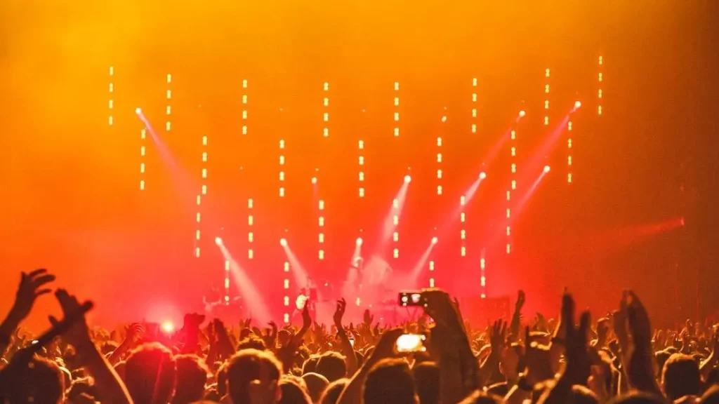 Energetic concert crowd enjoying bright stage lights, showcasing Charging Solutions for Events.