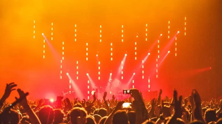 Energetic concert crowd enjoying bright stage lights, showcasing Charging Solutions for Events.